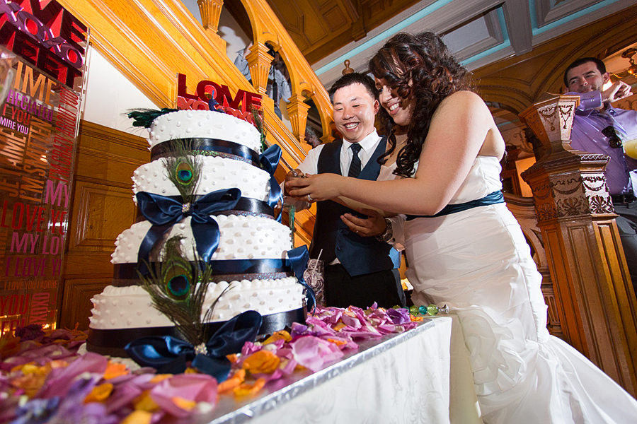 Peacock themed wedding cake Cutting the cake