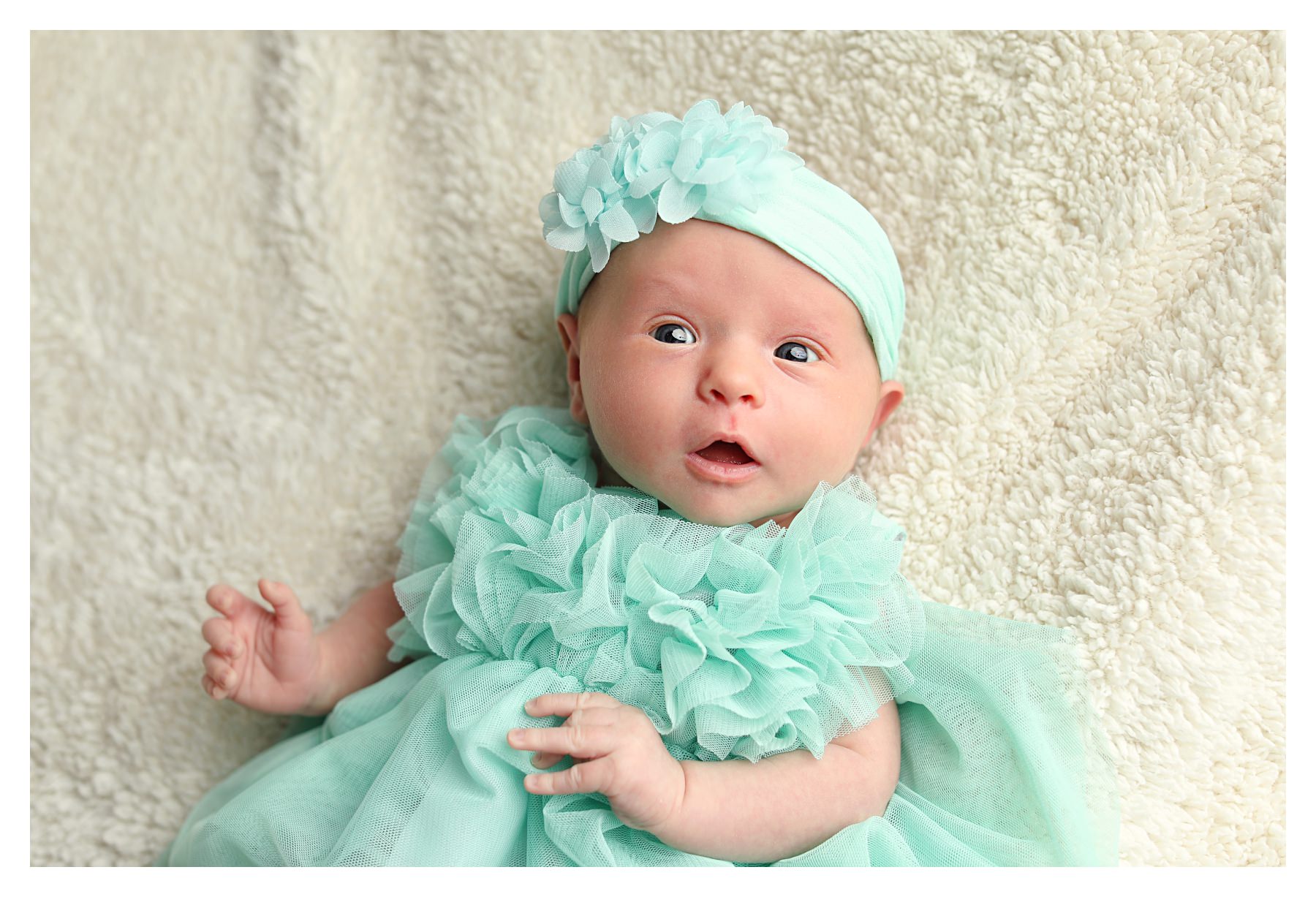 newborn photo studio picture with girl in teal dress