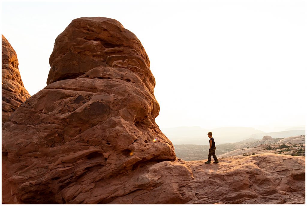 young boy walking at arches national park