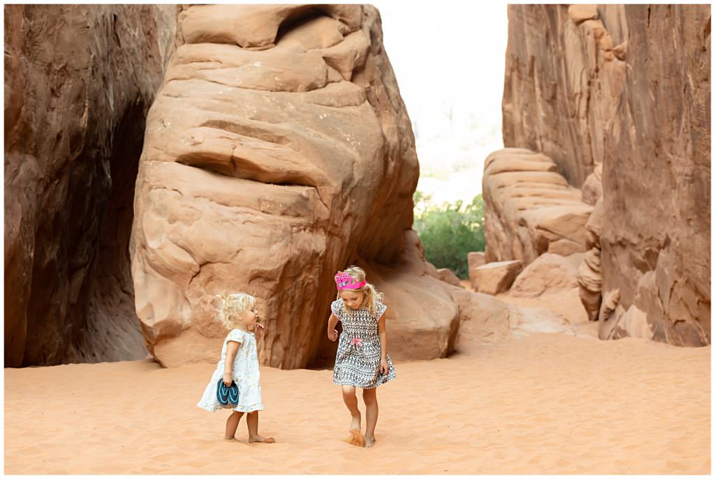 girls in sand at arches national park