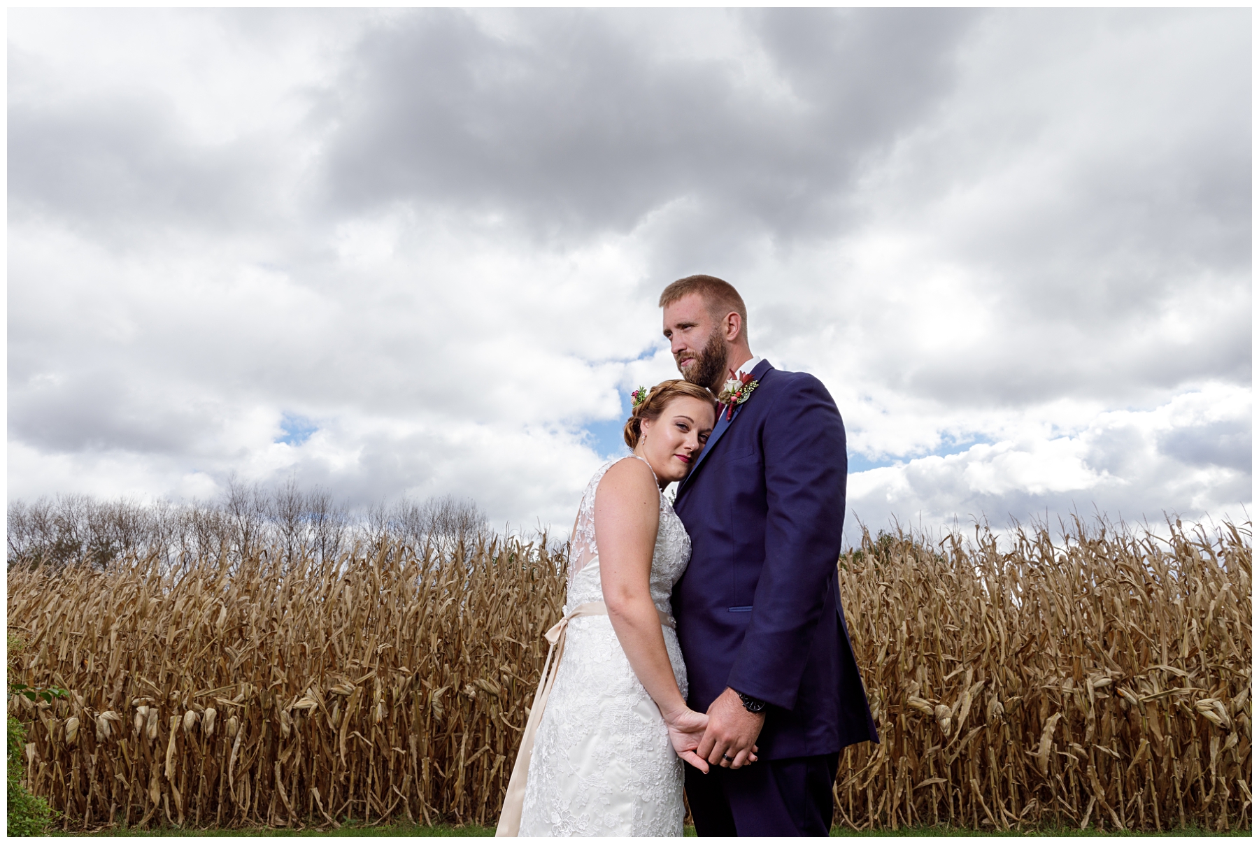 bride and groom poses with cornfield